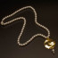 Collana con perle bianche in resina e pendente al centro disco in ottone color oro
